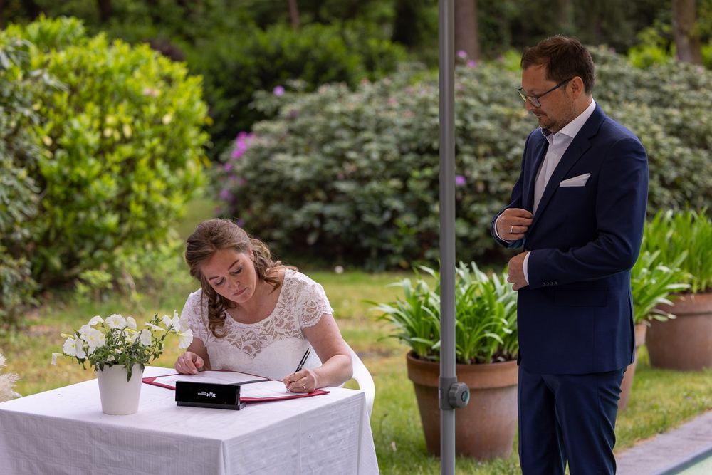 Bruid ondertekent trouwakte - documentaire bruidsreportage aan huis - Teteringen in eigen achtertuin - MaxFotos