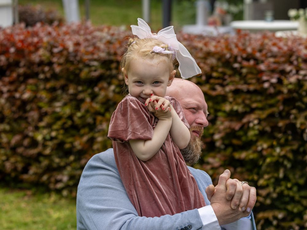 Bruidsmeisje kijkt schattig in de camera tijdens de trouwceremonie  - bruidsreportage aan huis - Teteringen in eigen achtertuin - MaxFotos