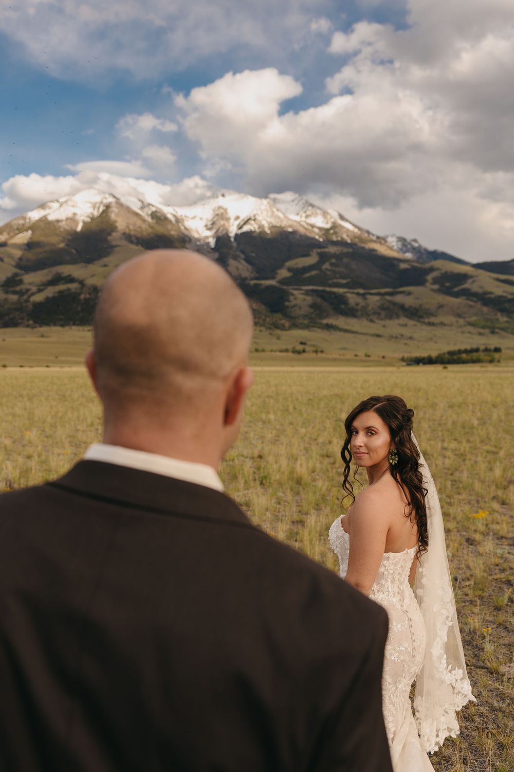 Paradise Valley bride looks back at groom under the Mountains in Pray, Montana captured by Sage Lodge Wedding Photographer Sabrina Marie