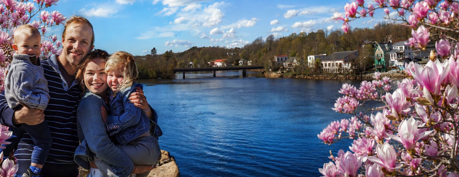 Bridgewater, on the La have River Family posing by a river with colorful houses in the background by Atlantic Memories Photography