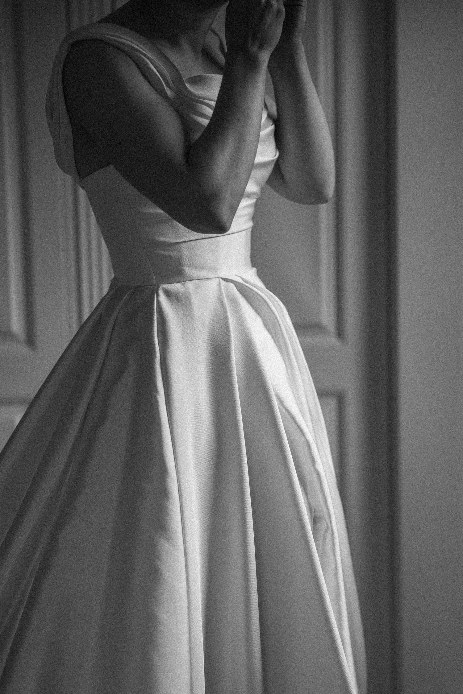 Elegant black and white photo of a bride in a classic satin ball gown wedding dress with a fitted bodice.