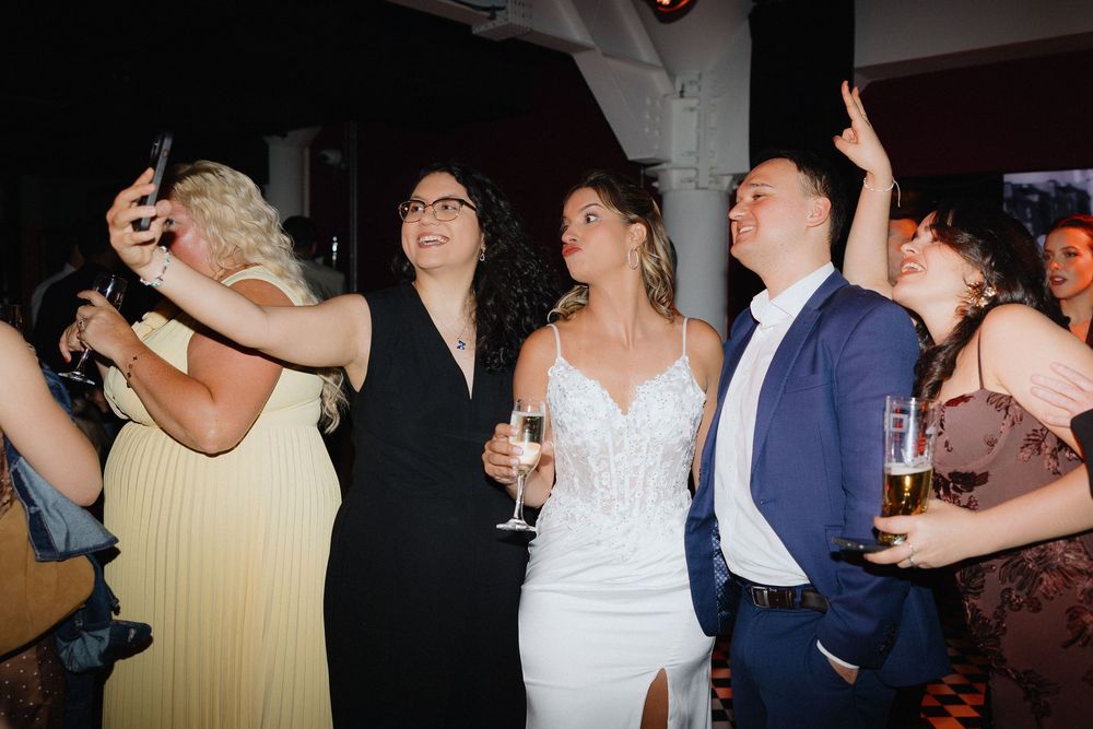 Wedding guests taking a selfie and dancing at a reception in Manchester