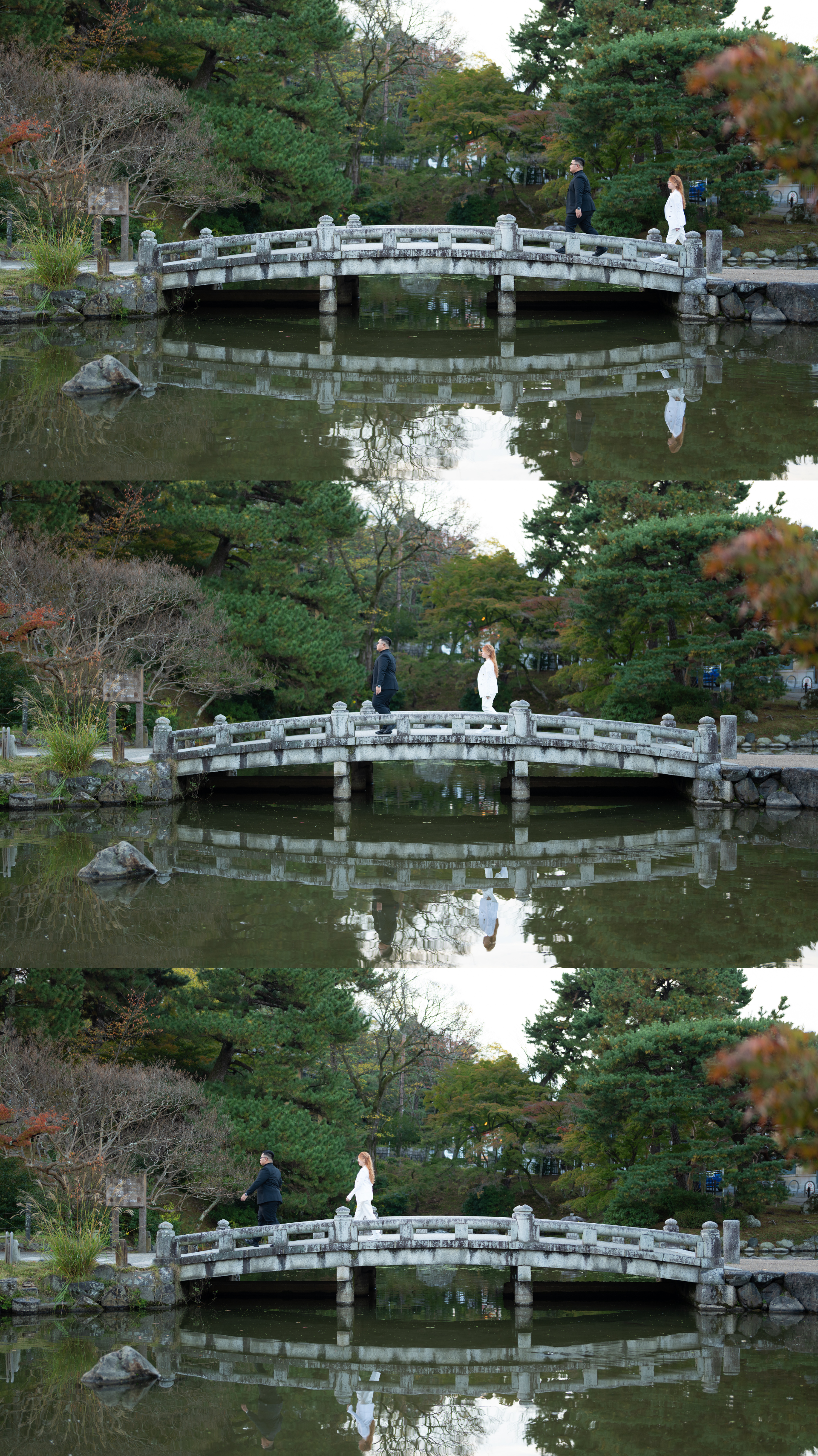 Couple on arched stone bridge reflected in calm pond of serene Japanese garden.