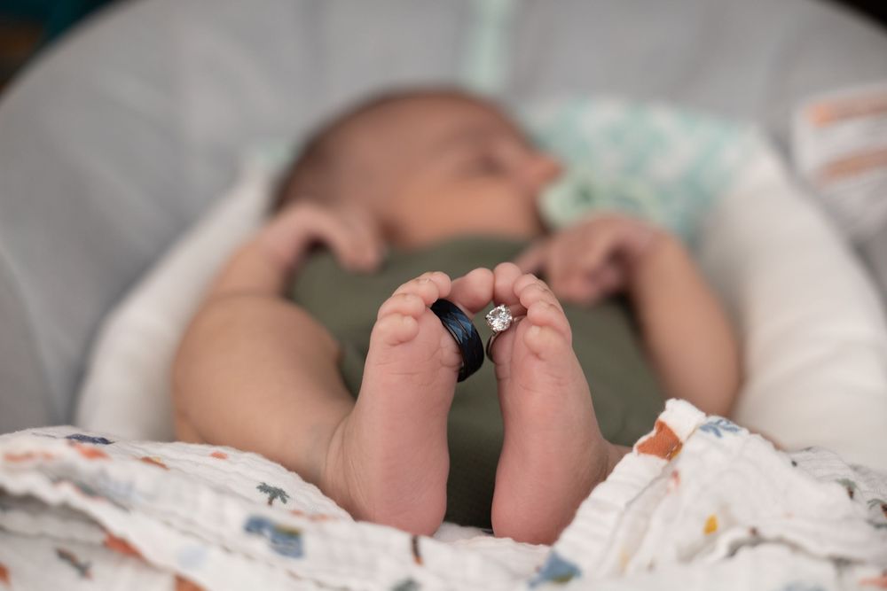 Newborn photoshoot using the parents engagement rings/wedding bands.