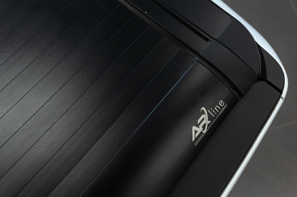 Close-up of black car roof panel featuring AR Line badge with textured surface detail.