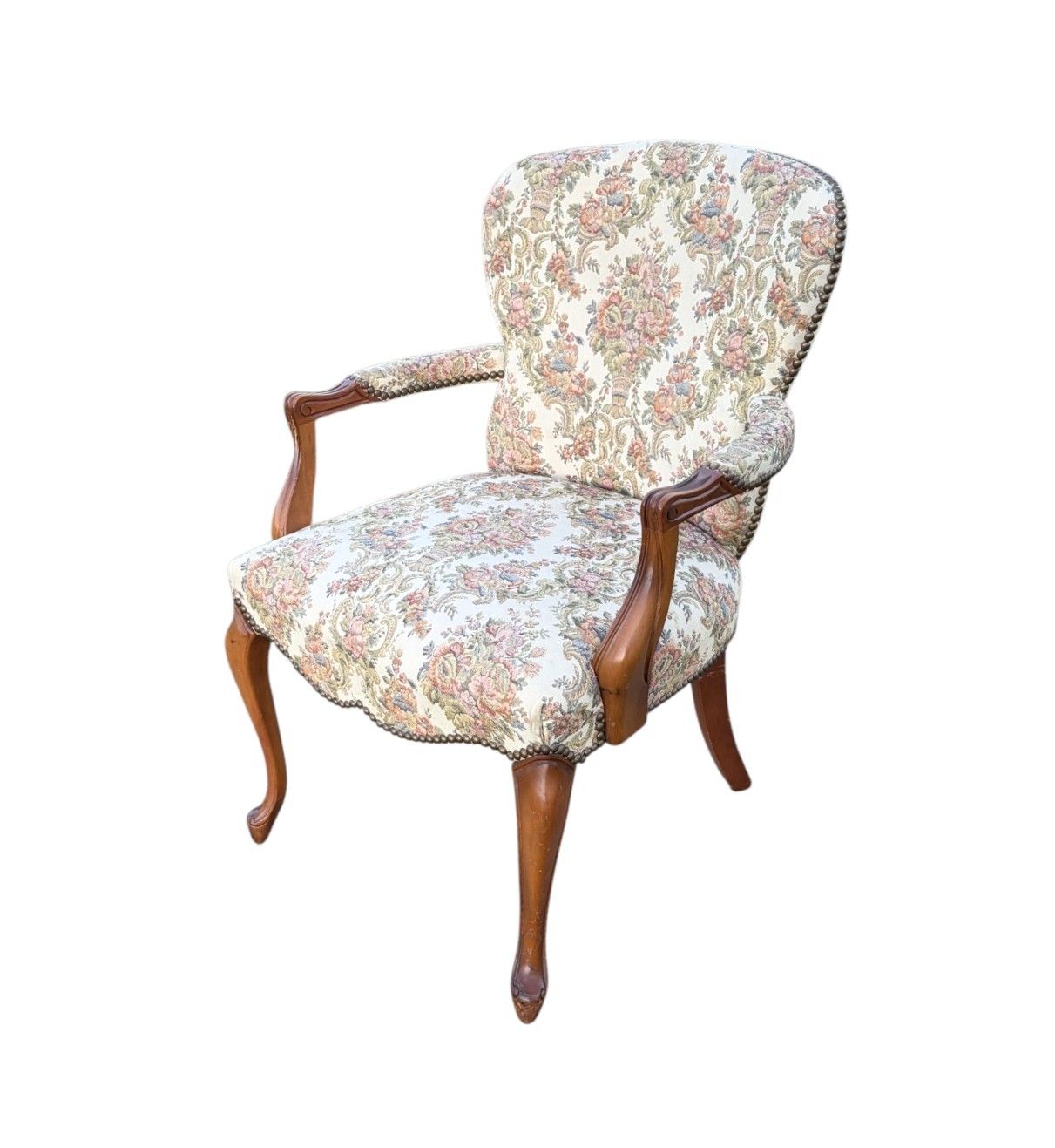 Two vintage pink velvet chairs with tufted upholstery and white painted frames sit on grass against green foliage.
