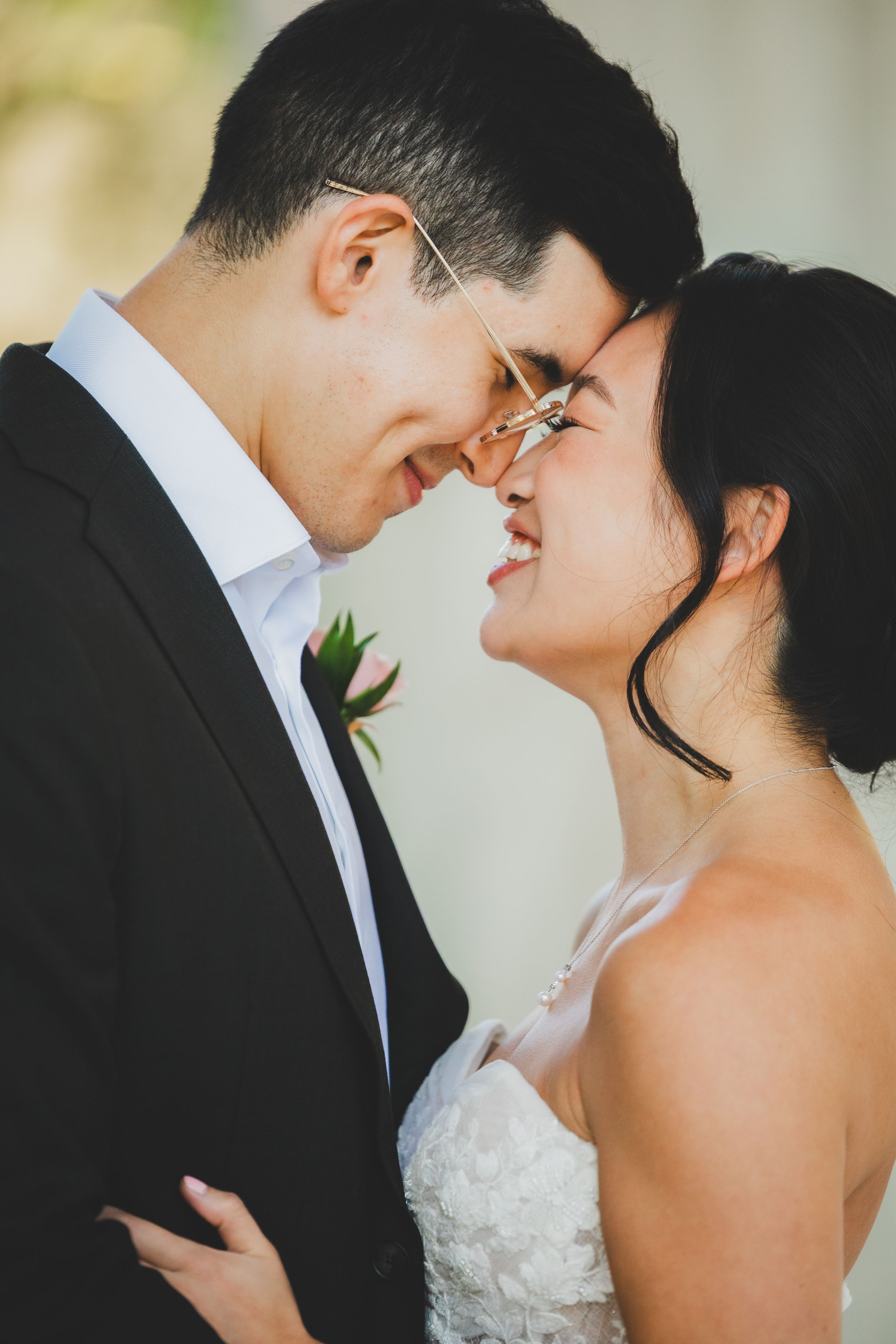 A bride and groom in wedding attire share an intimate moment, touching foreheads and smiling tenderly at the dc war memorial