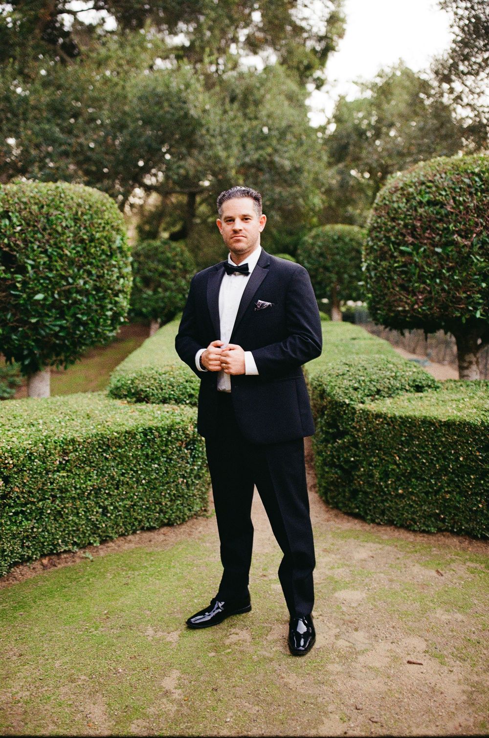 groom in tuxedo poses on wedding day in california wedding in hope ranch santa barbara