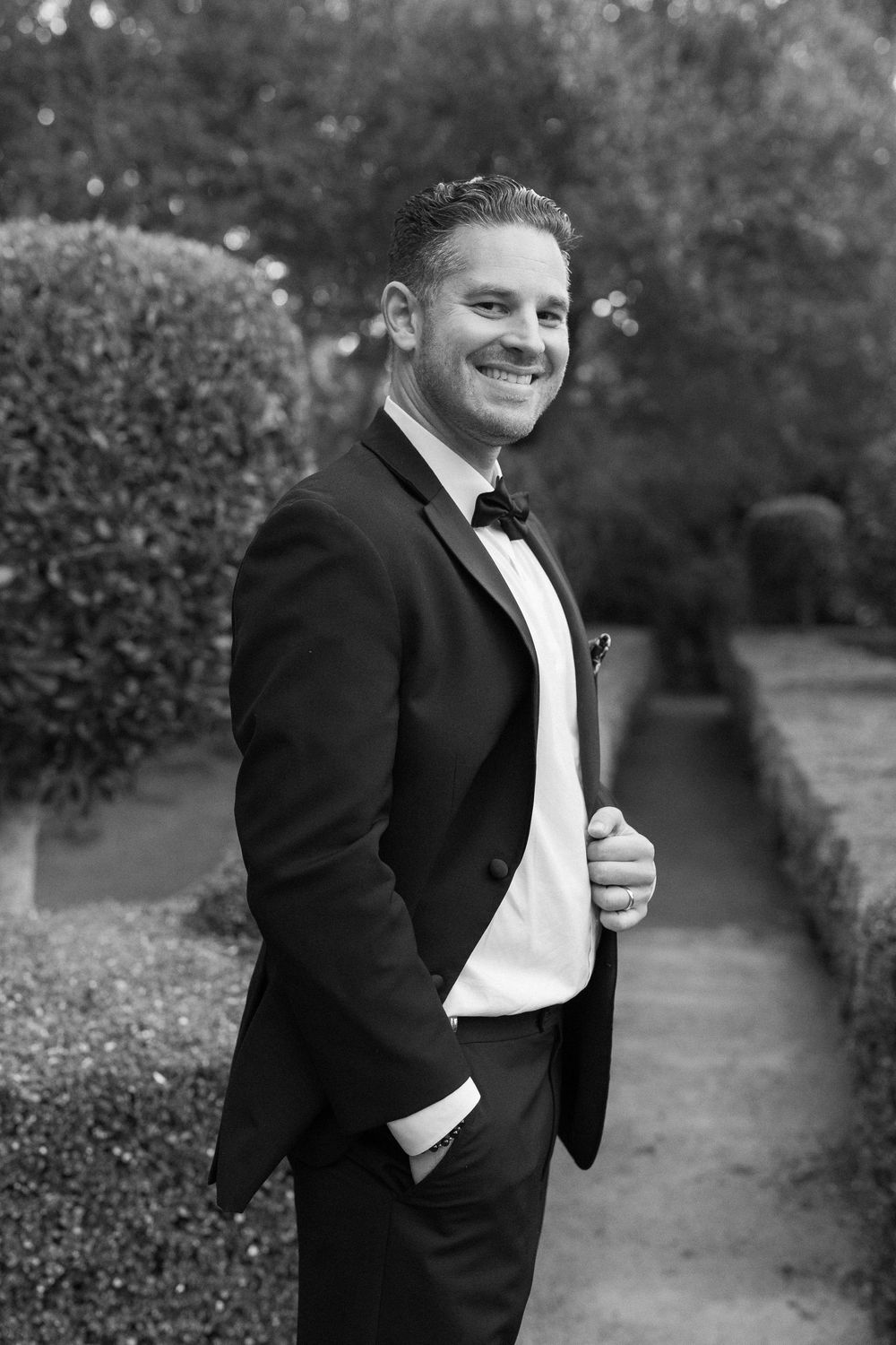 Classic black and white photo of groom standing in courtyard in SB