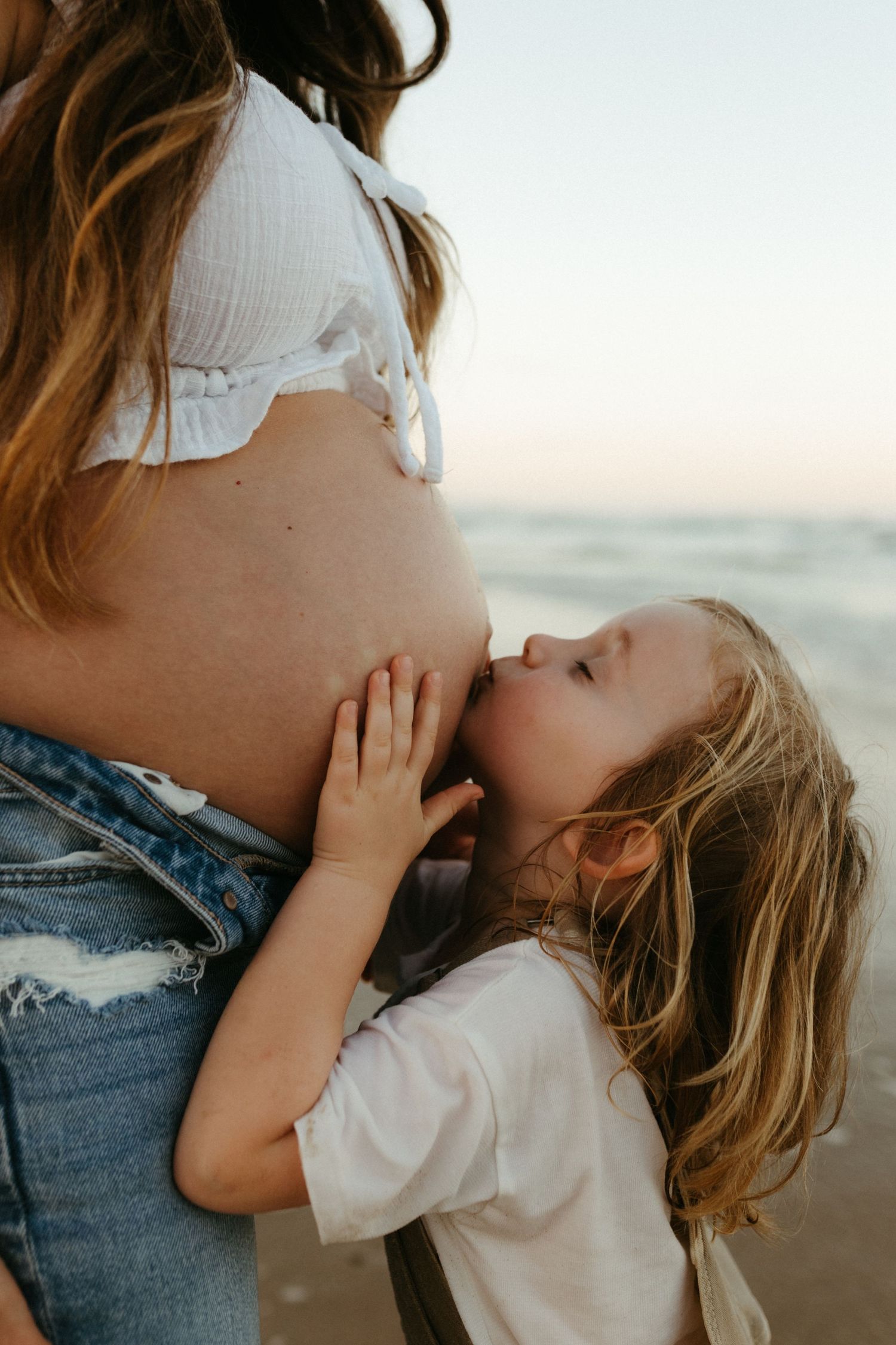 A pregnant women sitting naked in the grass