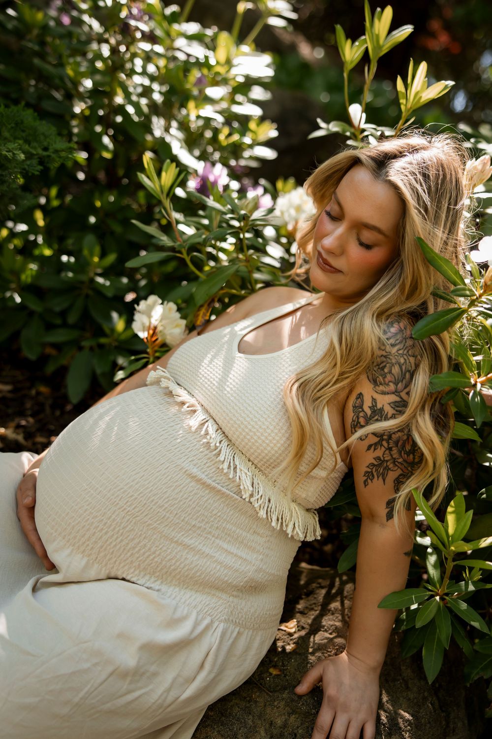 maternity photo woman sitting in flower bed at Scentsy Commons Meridian Idaho Milestones Portraits