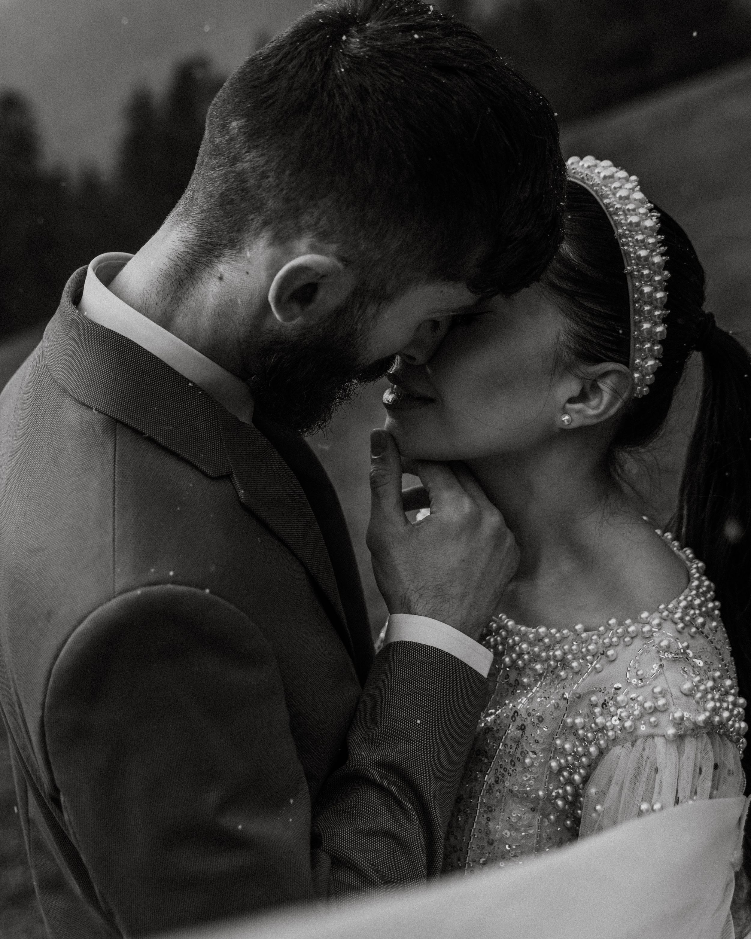 Bride and groom in a snowy forest with an intimate moment in a wedding in the Rockies.