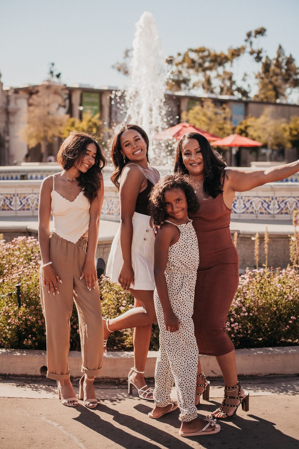 A family of four pose in front of a fountain in Balboa Park, San Diego.