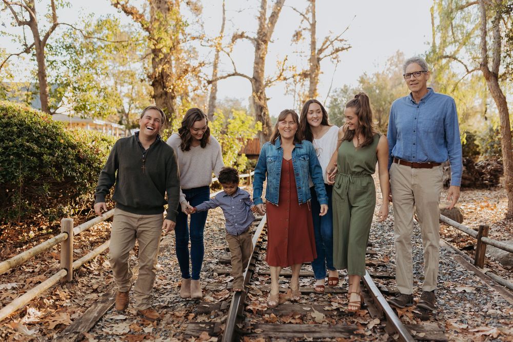 A large family walks along the train tracks in Autumn at Old Poway Park.