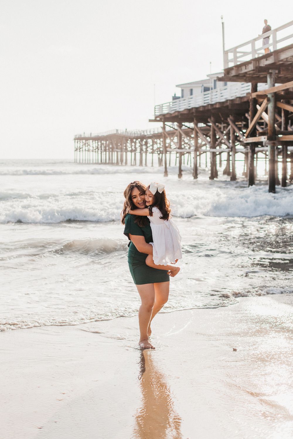 A mother holds her daughter on the beach in San Diego.