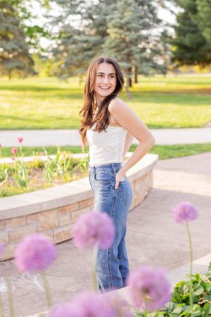 Senior girl session with girl standing near purple flowers blooming in Springfield, Missouri.