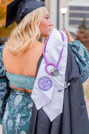 Close-up of graduation stole with medical symbol showing against academic regalia in Springfield, Missouri.