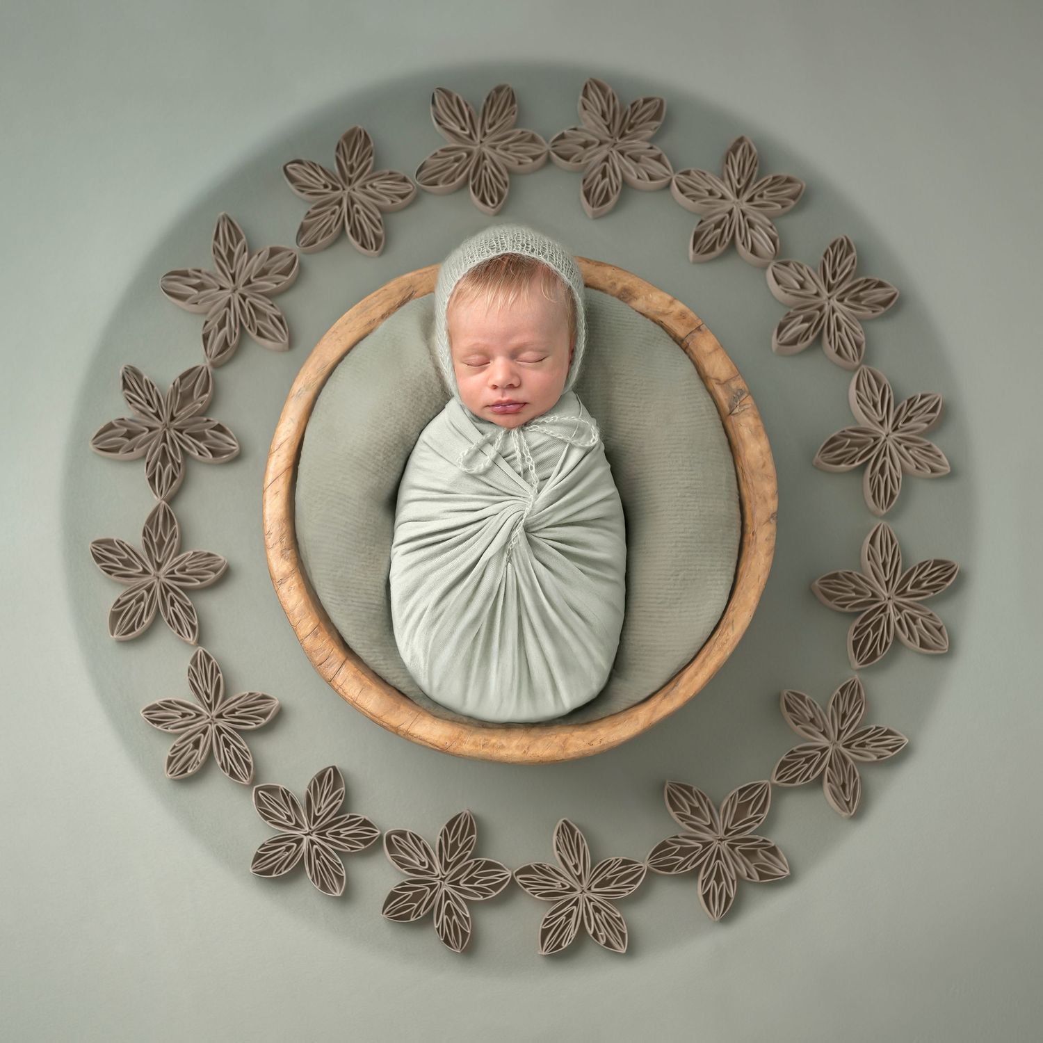 newborn baby sleeping wrapped in olive green wrap in Ashford, Kent studio