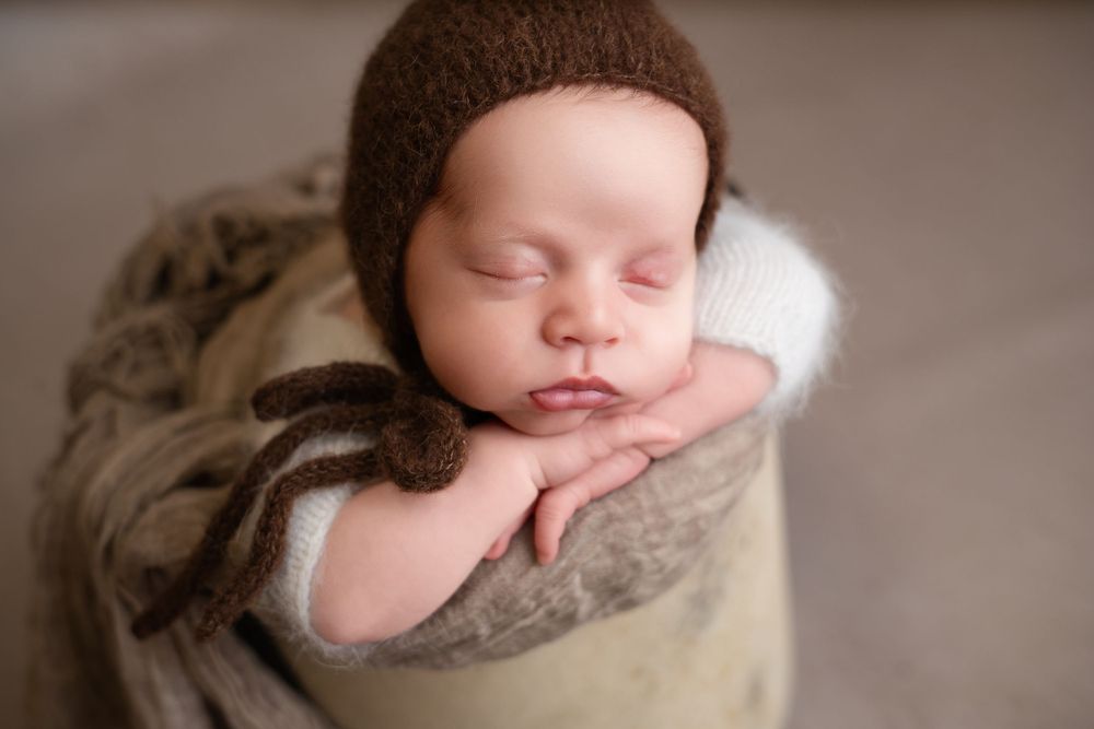 A close-up of a newborn baby peacefully sleeping, wrapped in soft fabric, photographed in Brandy Lee’s signature boutique style in Concord,