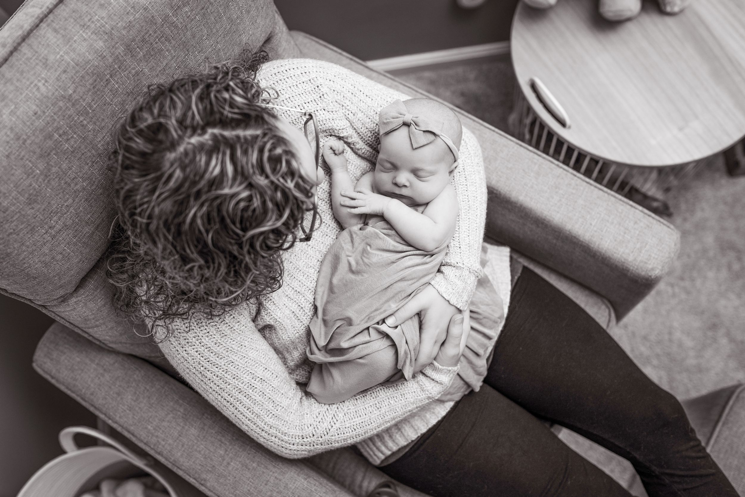 A mother holding her newborn baby, captured in an intimate moment by Brandy Aldrich, a Concord, NC-based boutique photographer.