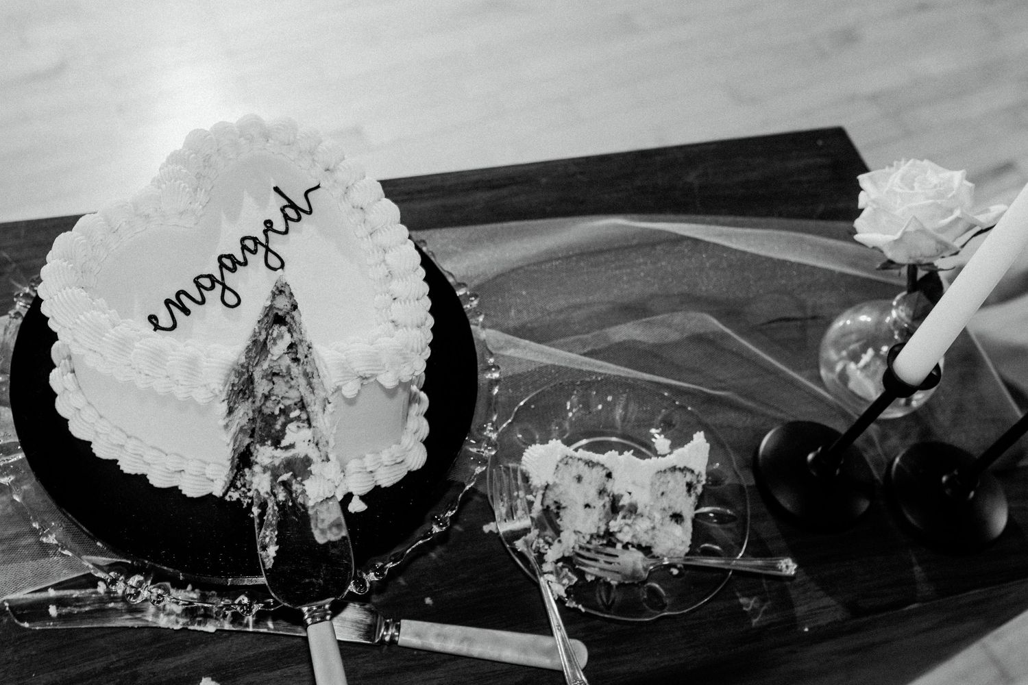 A black and white photograph of a smashed cake on what appears to be a car dashboard.