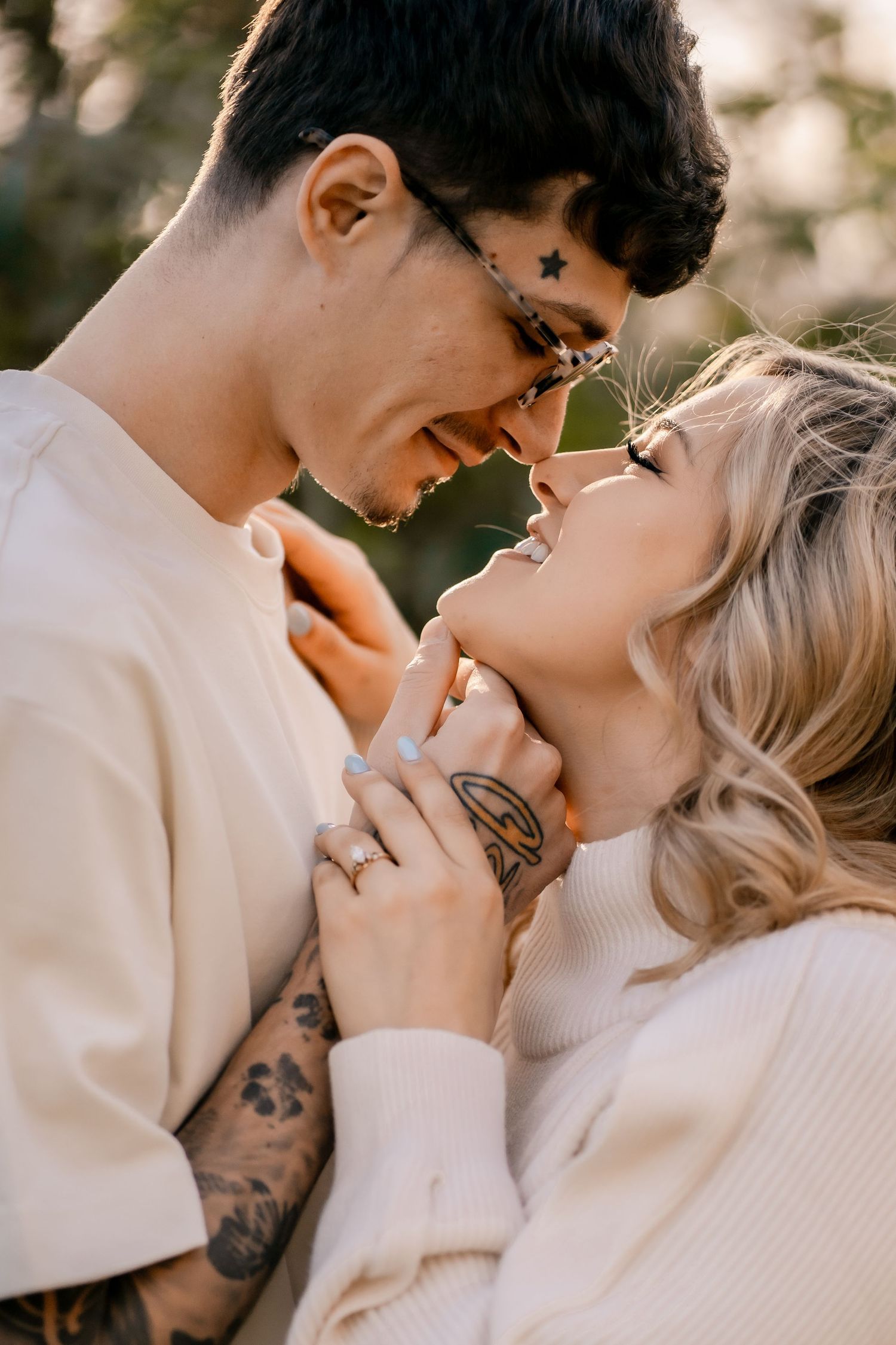 Intimate close-up of couple in cream sweaters sharing tender moment.