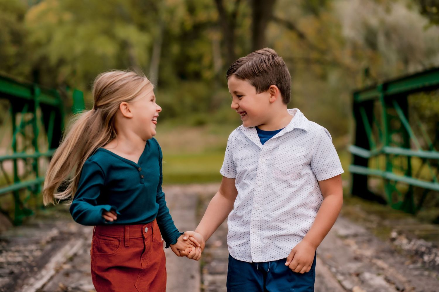 Children playing and walking together on a rustic bridge outdoors.
