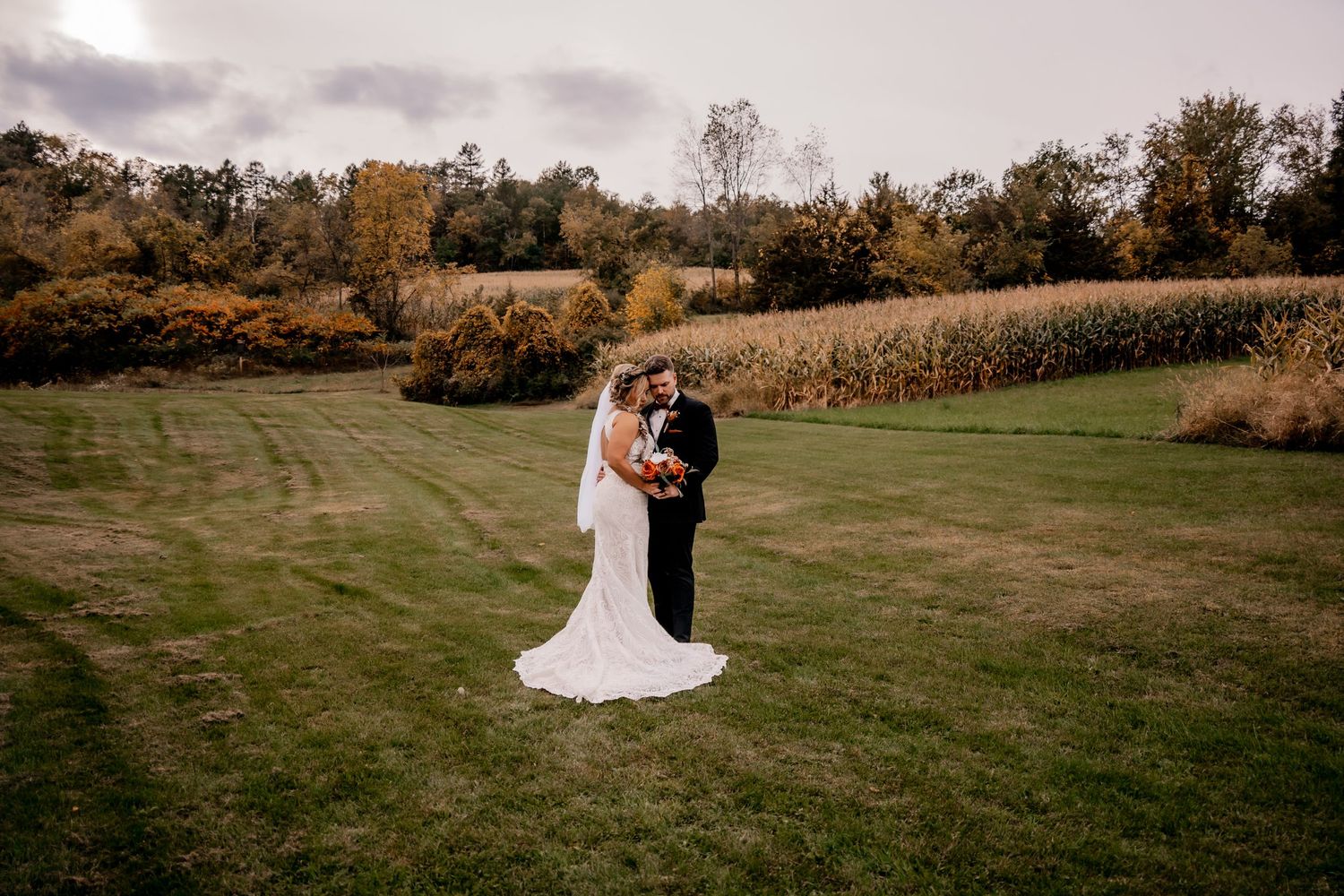 Panoramic view of a wedding ceremony in a scenic outdoor field during autumn.