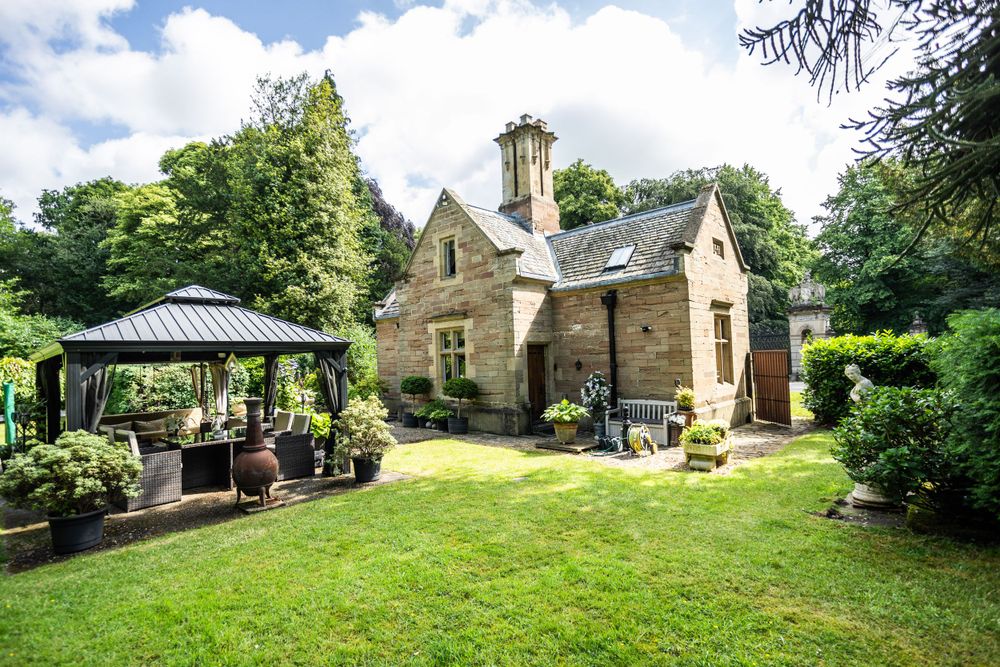 Charming stone cottage with outdoor gazebo seating area and landscaped garden.