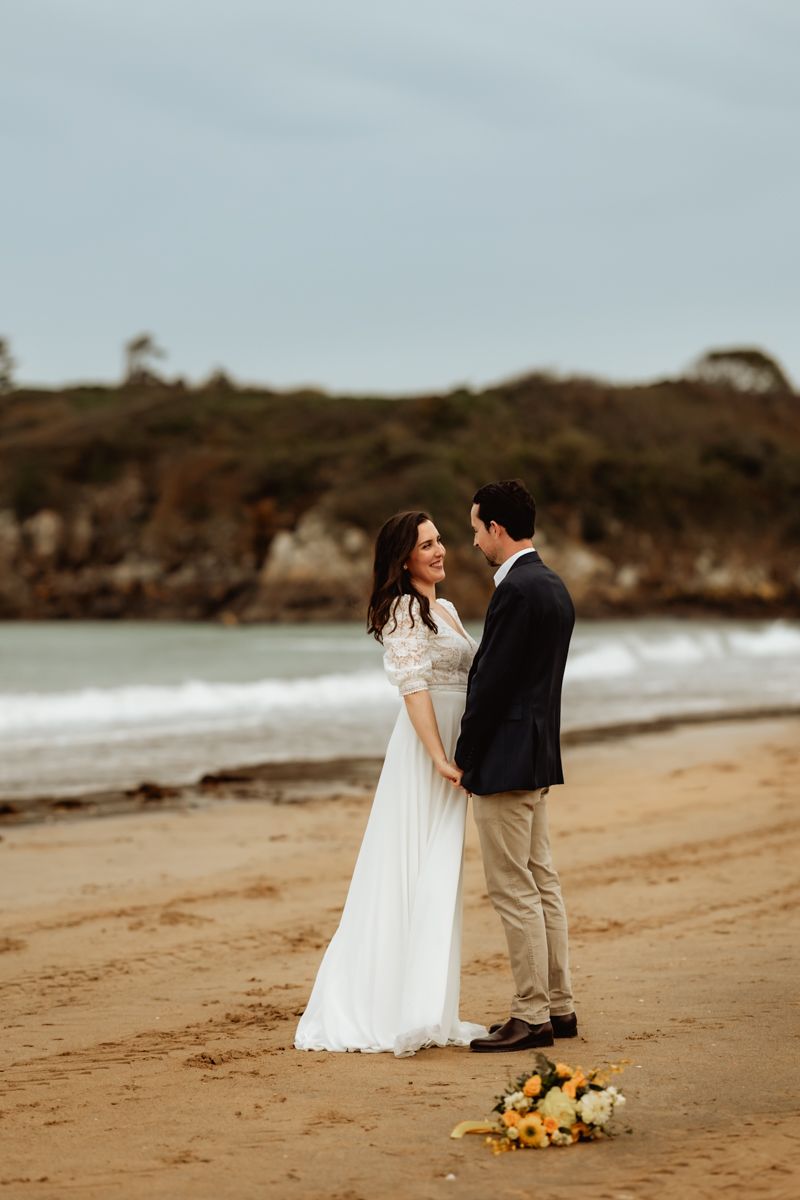Séance couple de mariés à la plage durant leur journée de mariage
