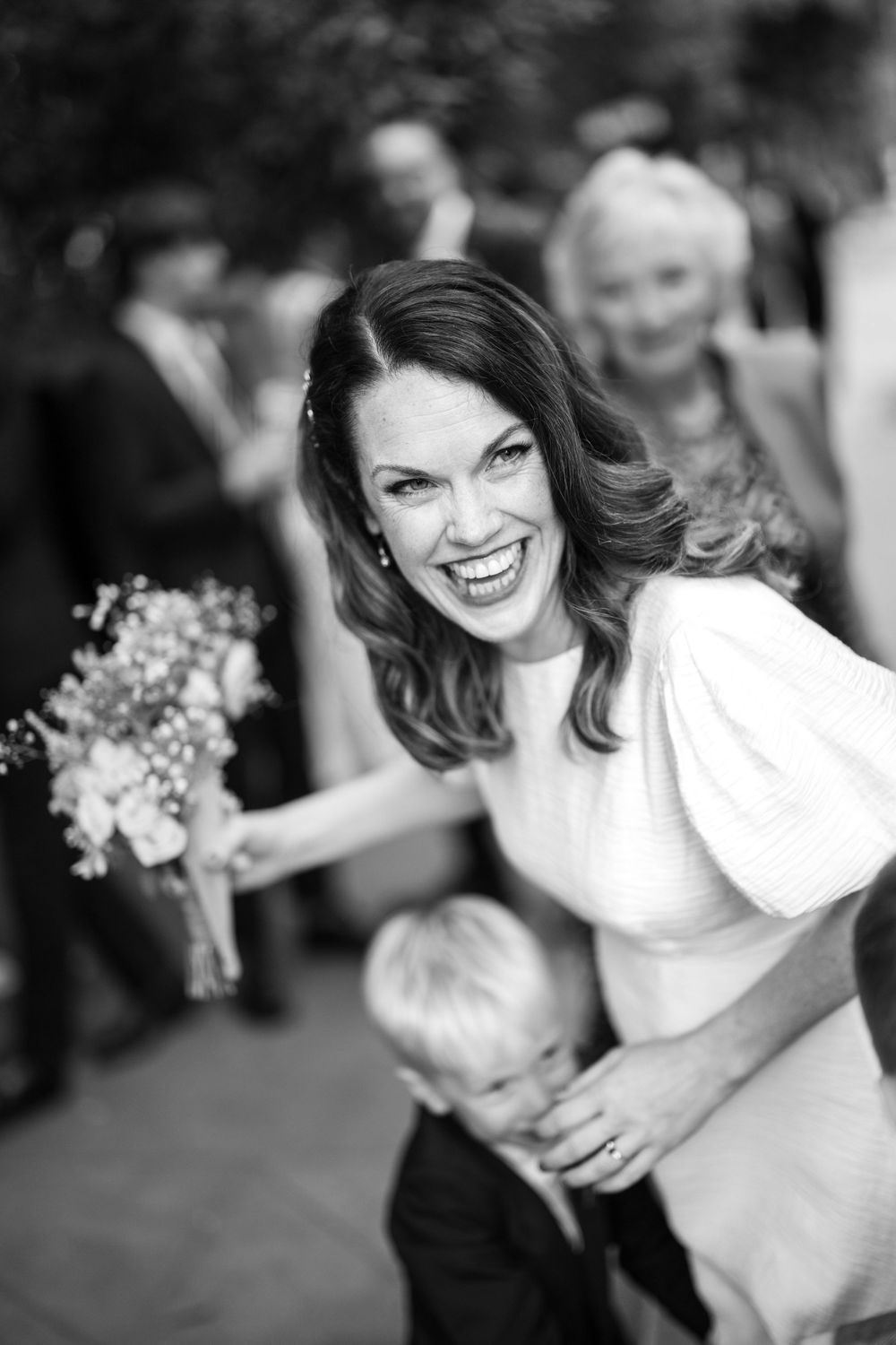 Black and white portrait of bride holding flowers at a wedding celebration.