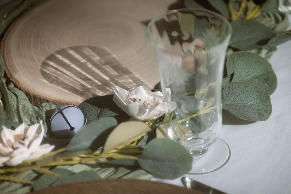 A wedding scene with rings and flowers arranged on a rustic wooden surface with soft lighting.