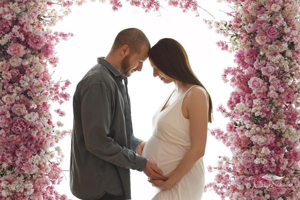 A romantic engagement photoshoot sequence with pink cherry blossoms framing the couple's special moment.