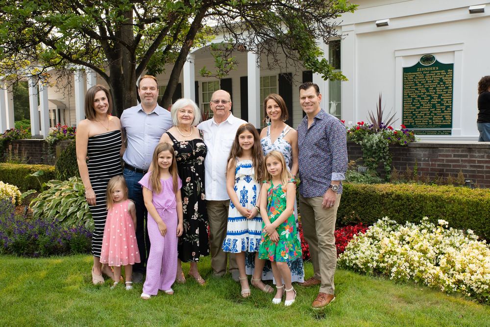 A series of outdoor family portraits with people posing together in gardens and backyard settings during spring or summer.