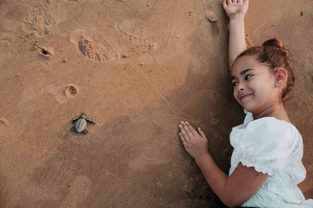 Petite fille souriante jouant sur le sable