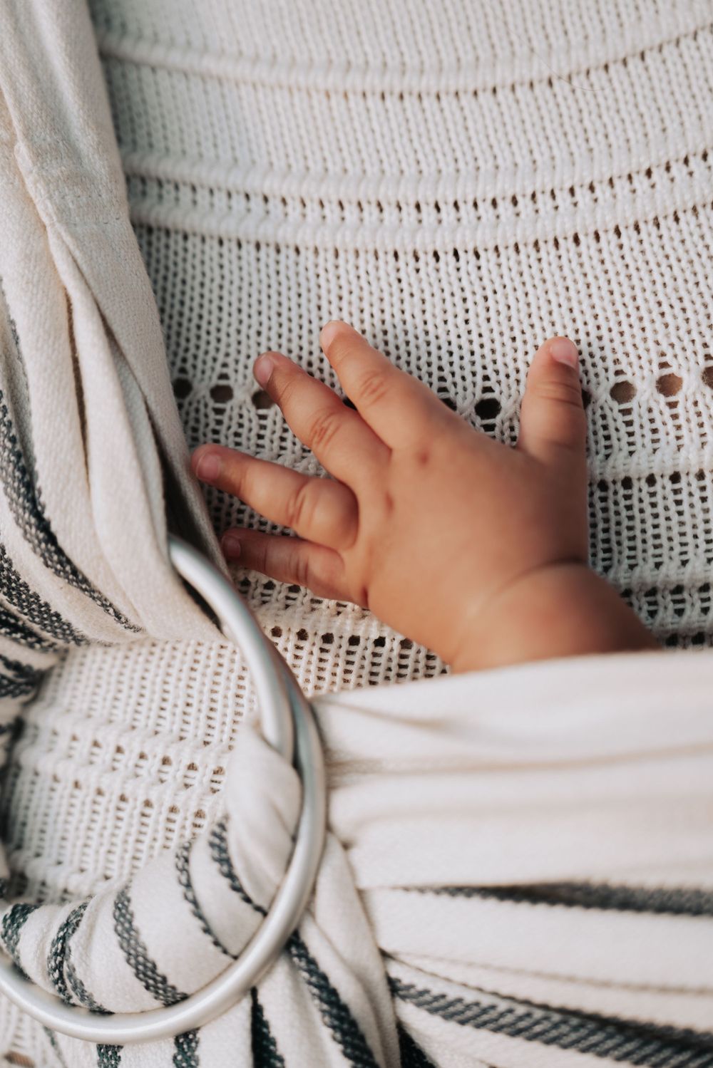 Main de bébé sur un tissu en tricot, séance nouveau-né