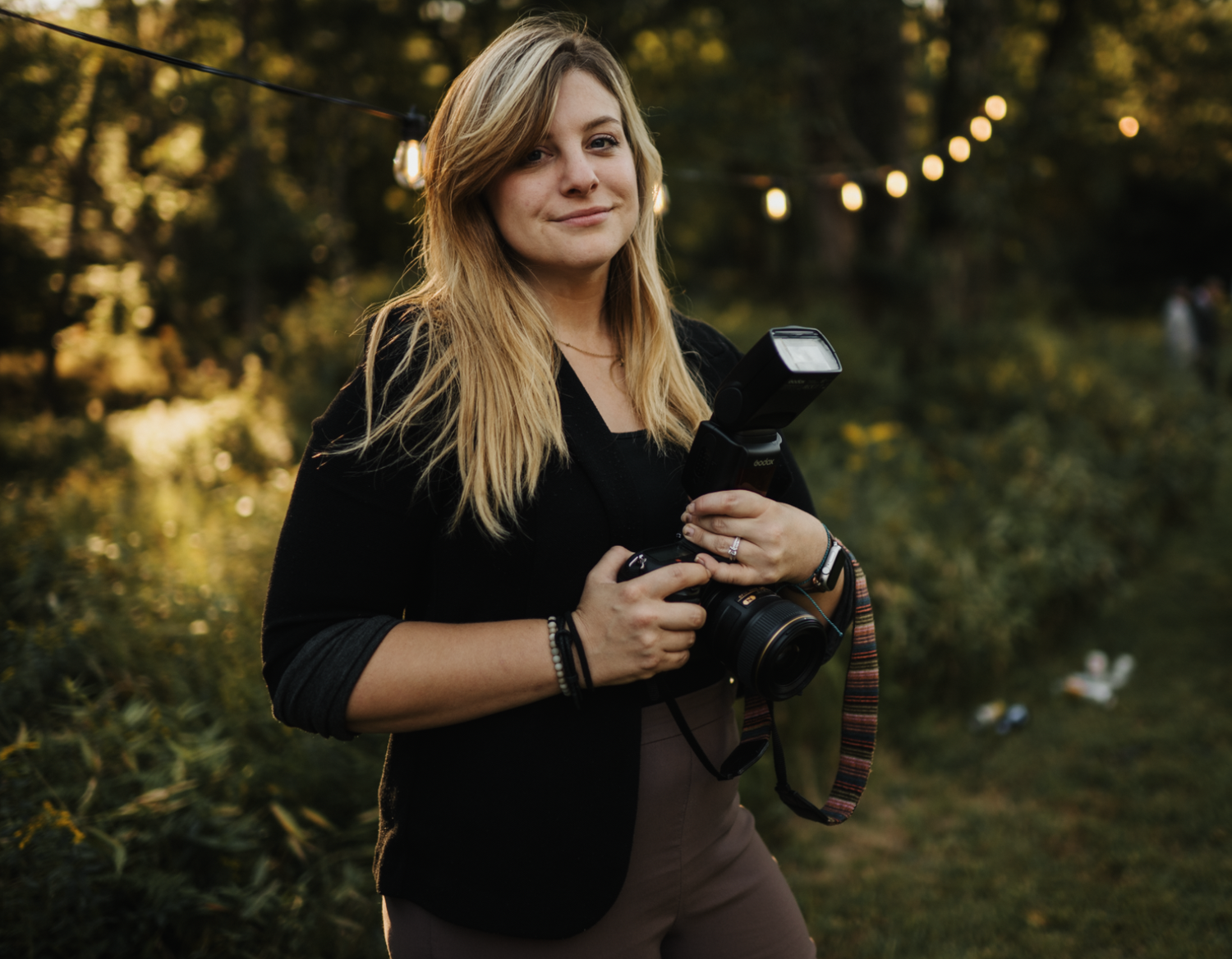 Photographer with camera equipment working in golden outdoor lighting.