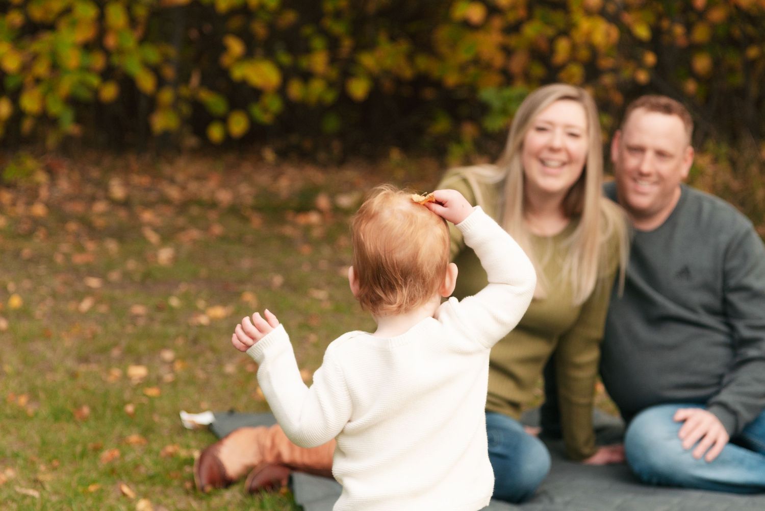 A playful family moment captured outdoors during autumn.