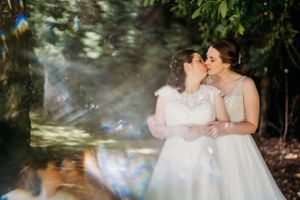 Dreamy garden wedding portrait with lens flare and romantic atmosphere.
