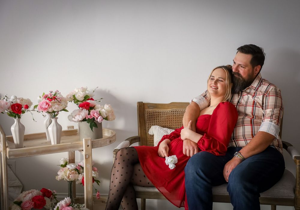 Cozy indoor couple's photography session with red and casual attire.