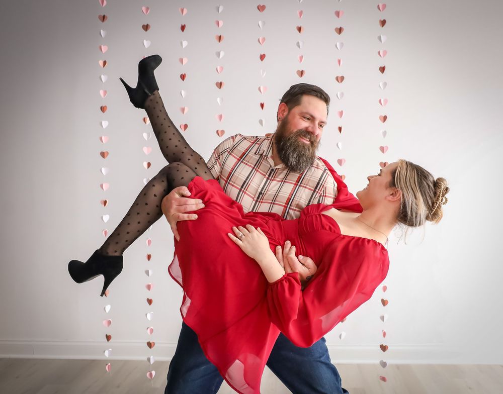 Valentine's themed photo shoot with hanging heart decorations and playful poses.