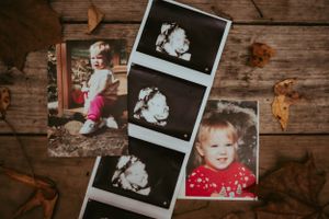 Collection of vintage polaroid photos spread out on rustic wooden surface.
