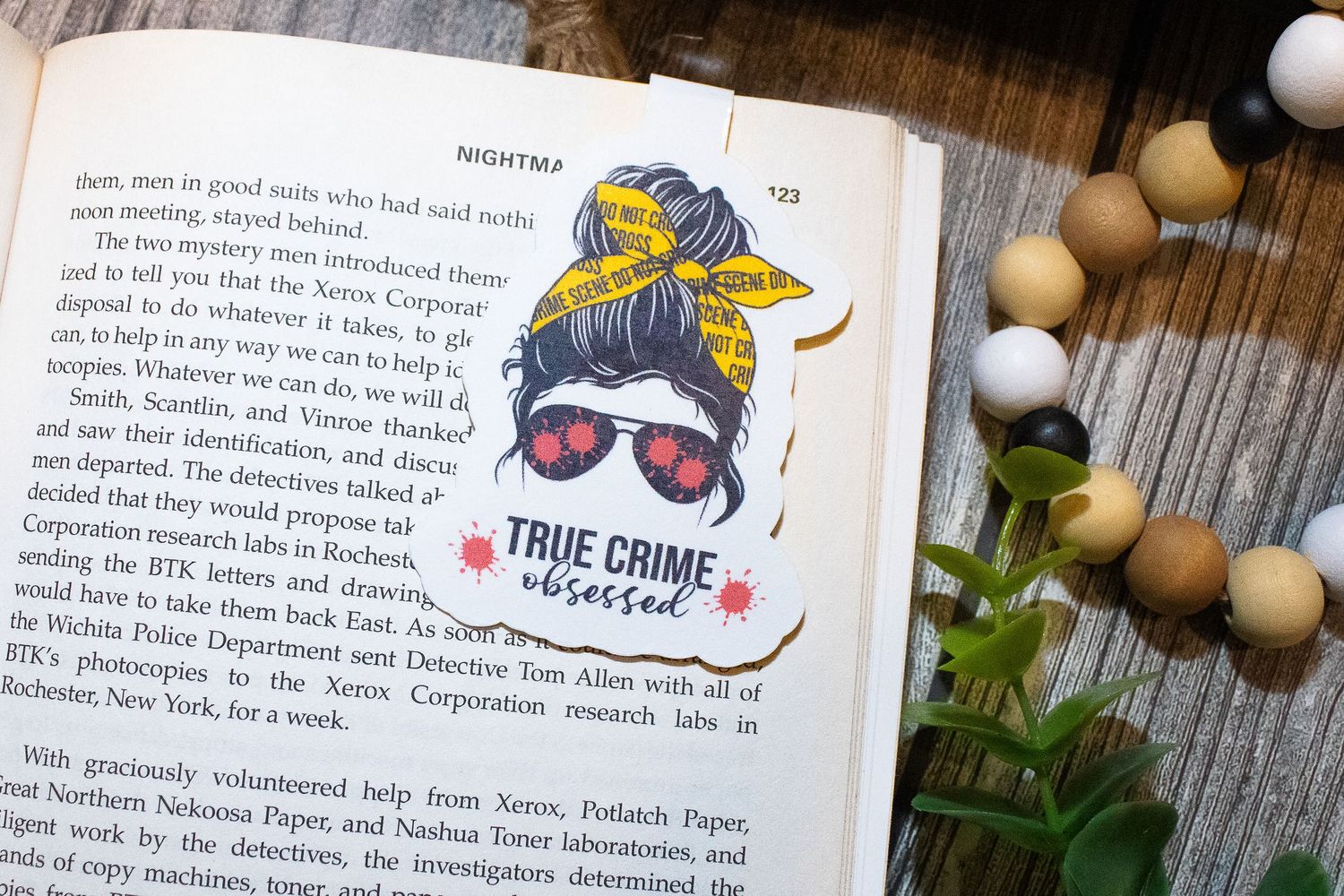 True crime stickers and decorative elements arranged on a wooden surface with text.