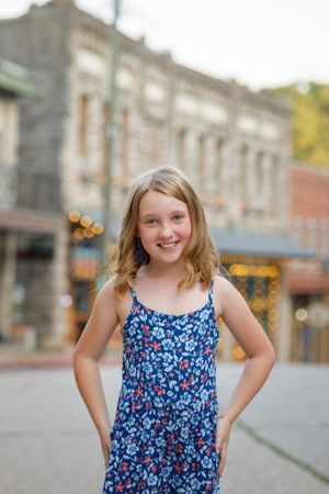 Cheerful portrait on historic small town street with brick buildings in background.