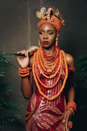 Stunning traditional African-inspired fashion with coral beaded jewelry and ornate headpiece.
