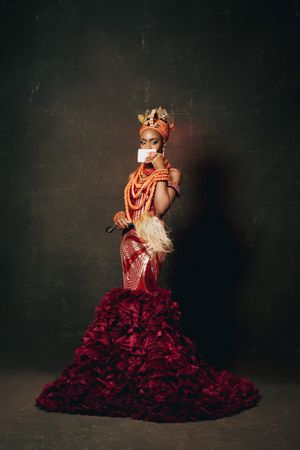 Dramatic fashion portrait with coral beads, ruffled red gown and traditional inspired styling.