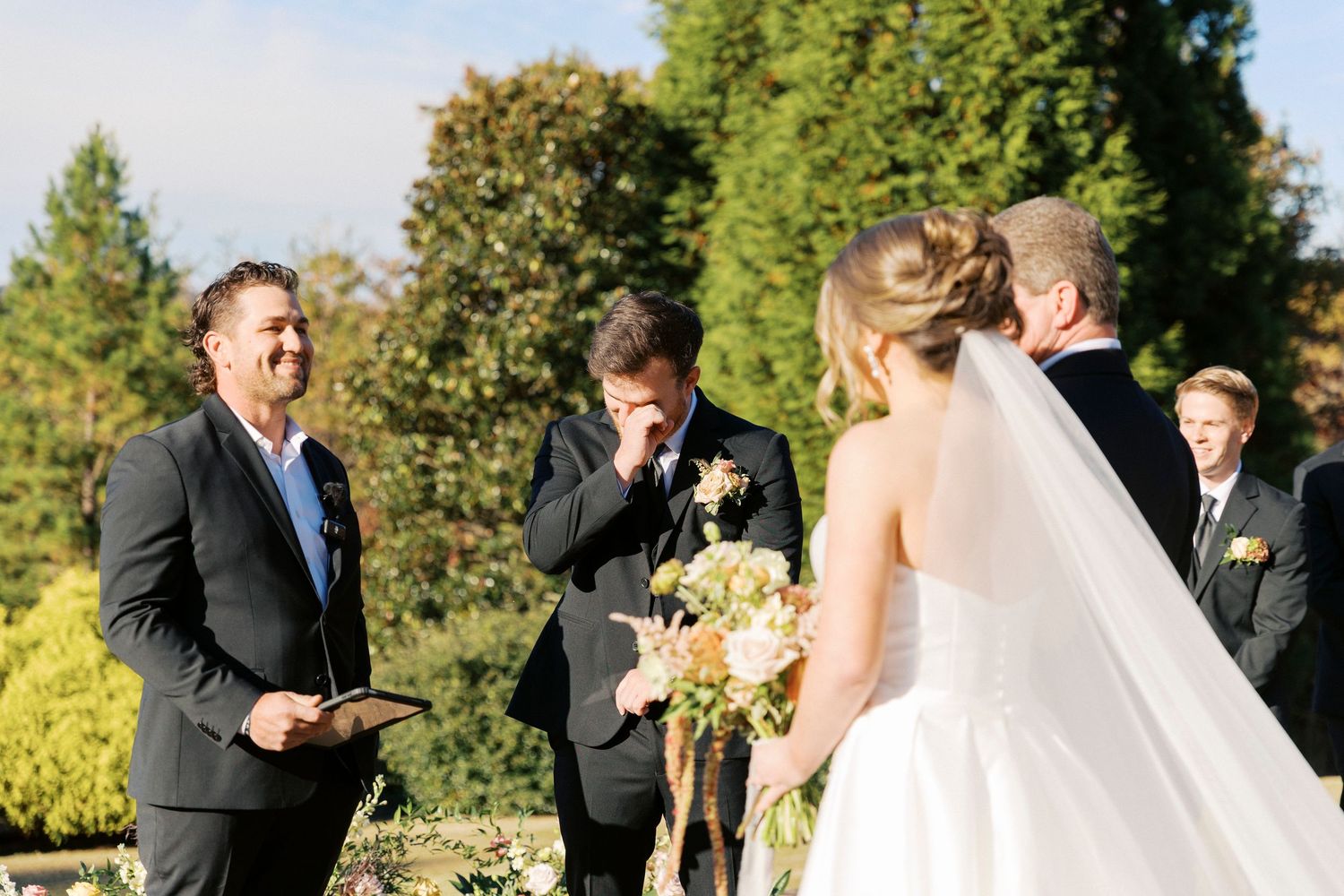 groom's emotional reaction to bride walking down aisle during wedding ceremony at blue mountain vineyards in dahlonega, georgia.