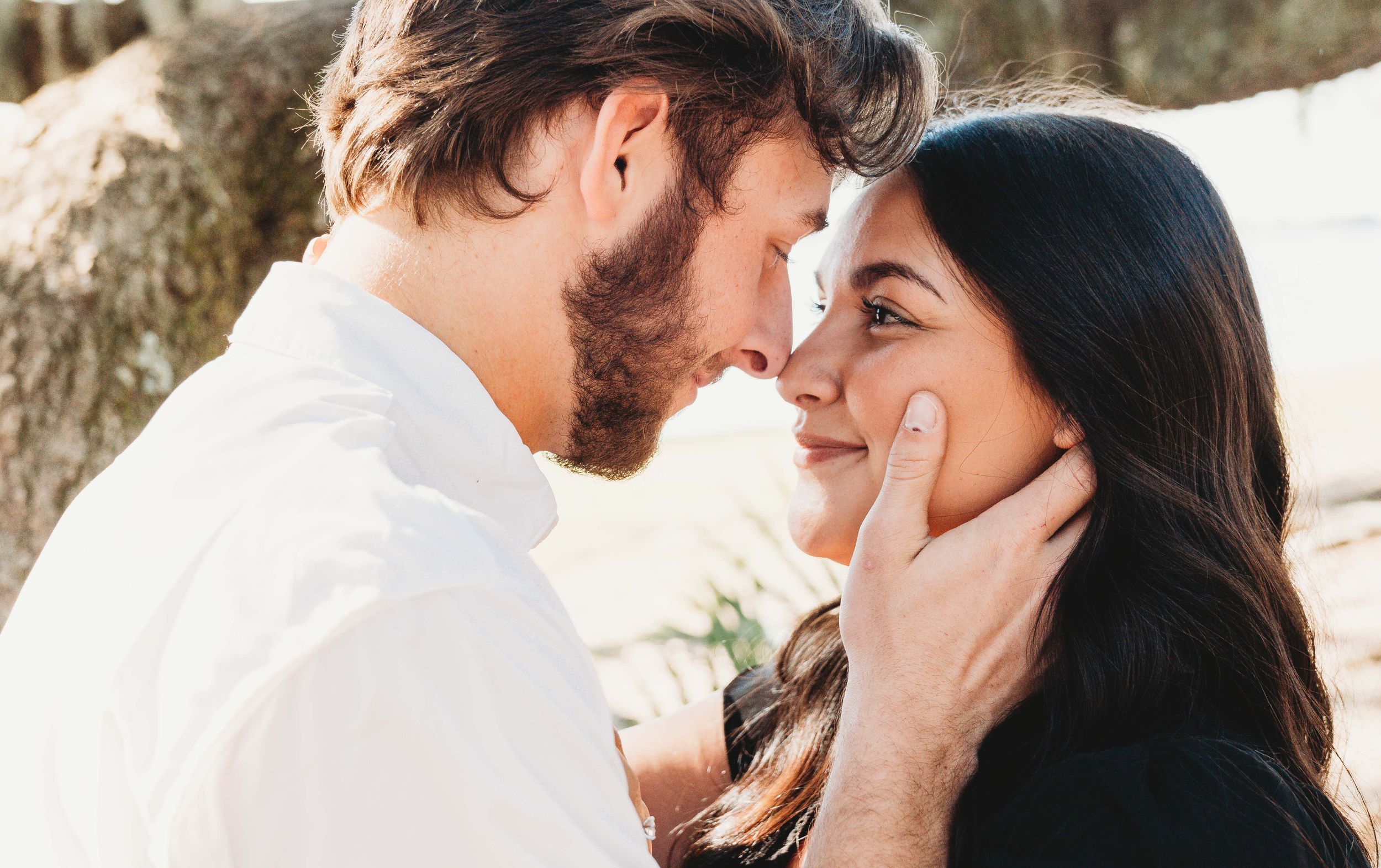 Intimate moment between two people sharing a tender embrace in natural lighting.