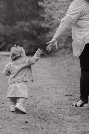 Black and white, little girl and mum going to hold hands, natural shot.