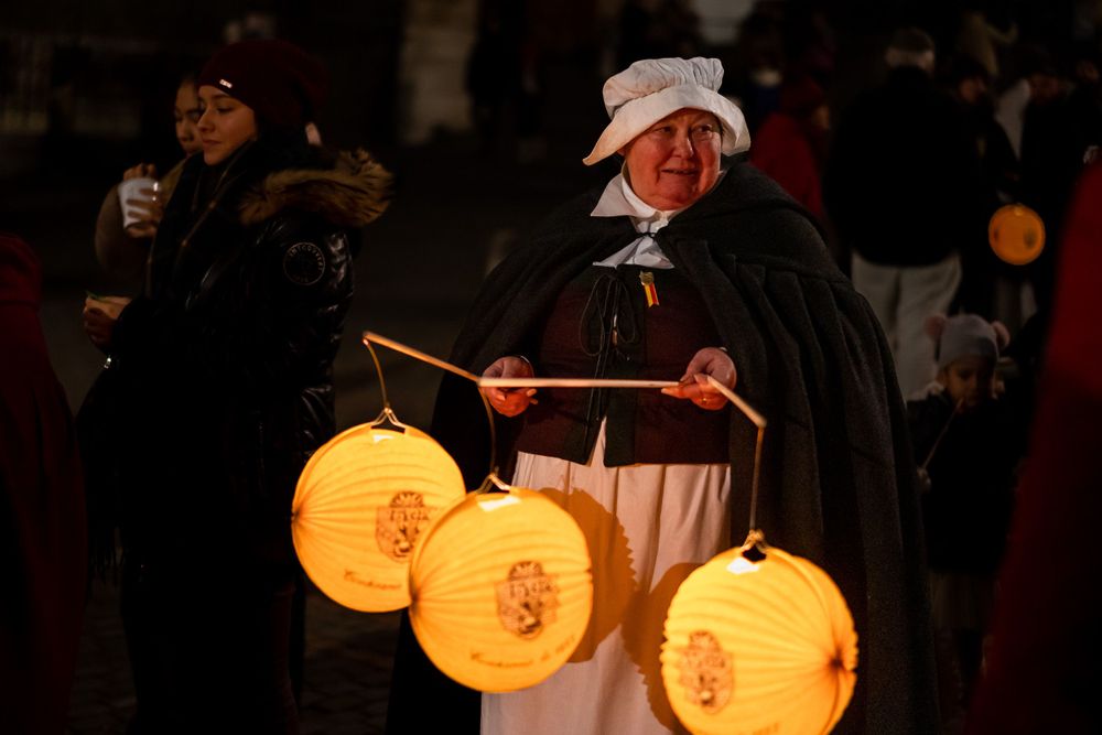 Multiple glowing paper lanterns being carried during a nighttime festival celebration.